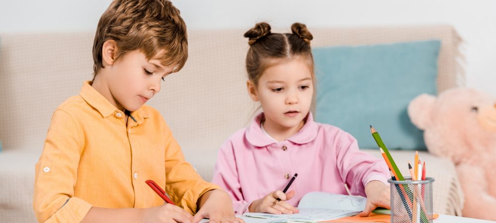adorable little children writing and studying together