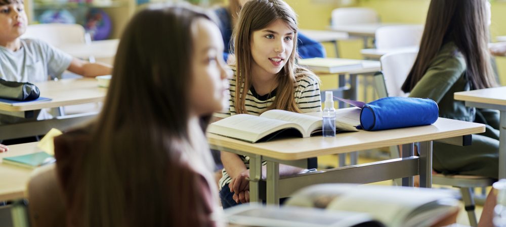 Primary schoolgirls sitting at classroom desks
