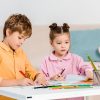 adorable little children writing and studying together